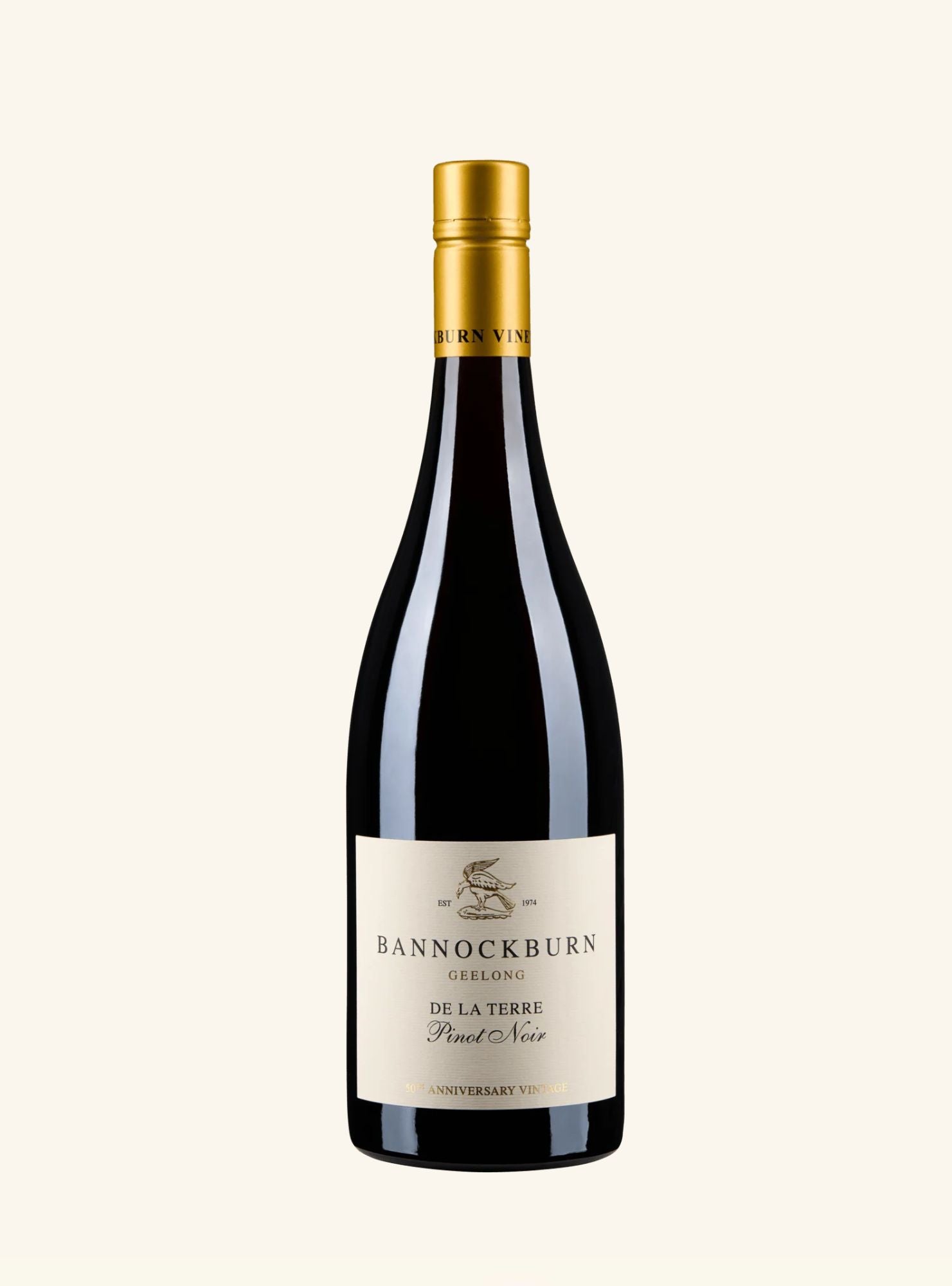 A bottle of Bannockburn de la terre red wine with a gold foil capsule and a cream-colored label, set against a solid off-white background.