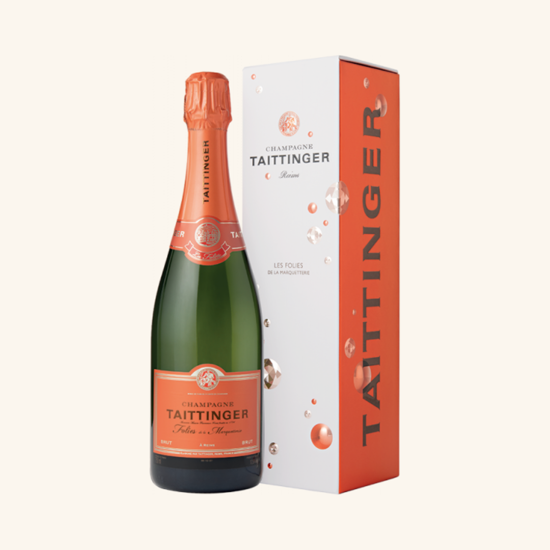 A bottle of Taittinger Folies de la Marquetterie NV champagne with its packaging box.