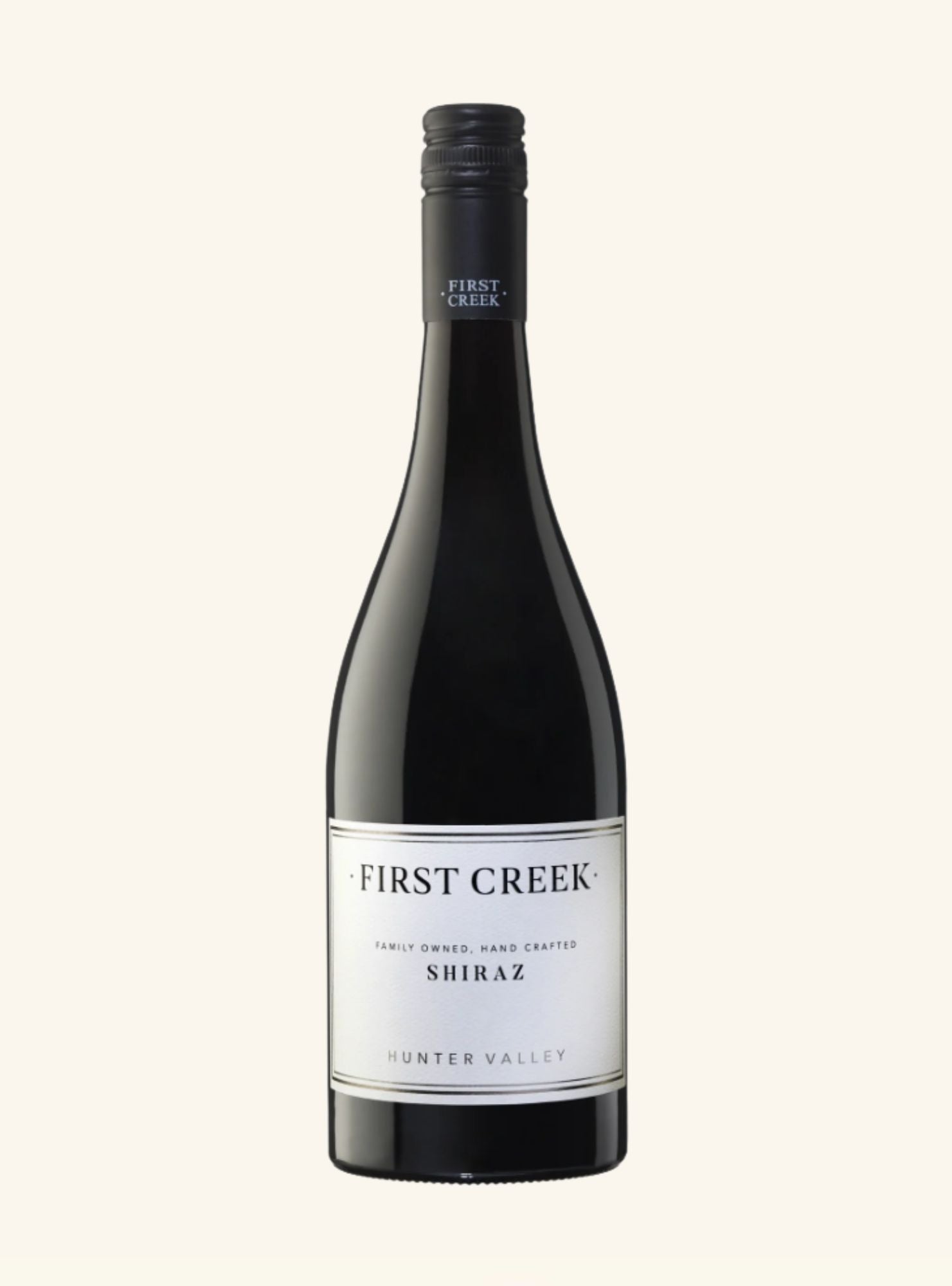 Dark coloured wine bottle with a black screw cap and a white label with black writing.