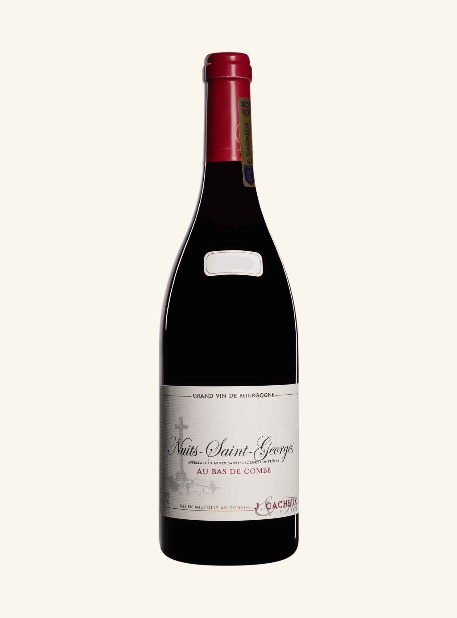 A bottle of red wine from the brand J.Cacheux, specifically from the region nuit-Saint-Greorges  au Bas de Combe', with a red foil capsule and a white label, shown against a plain off-white background.