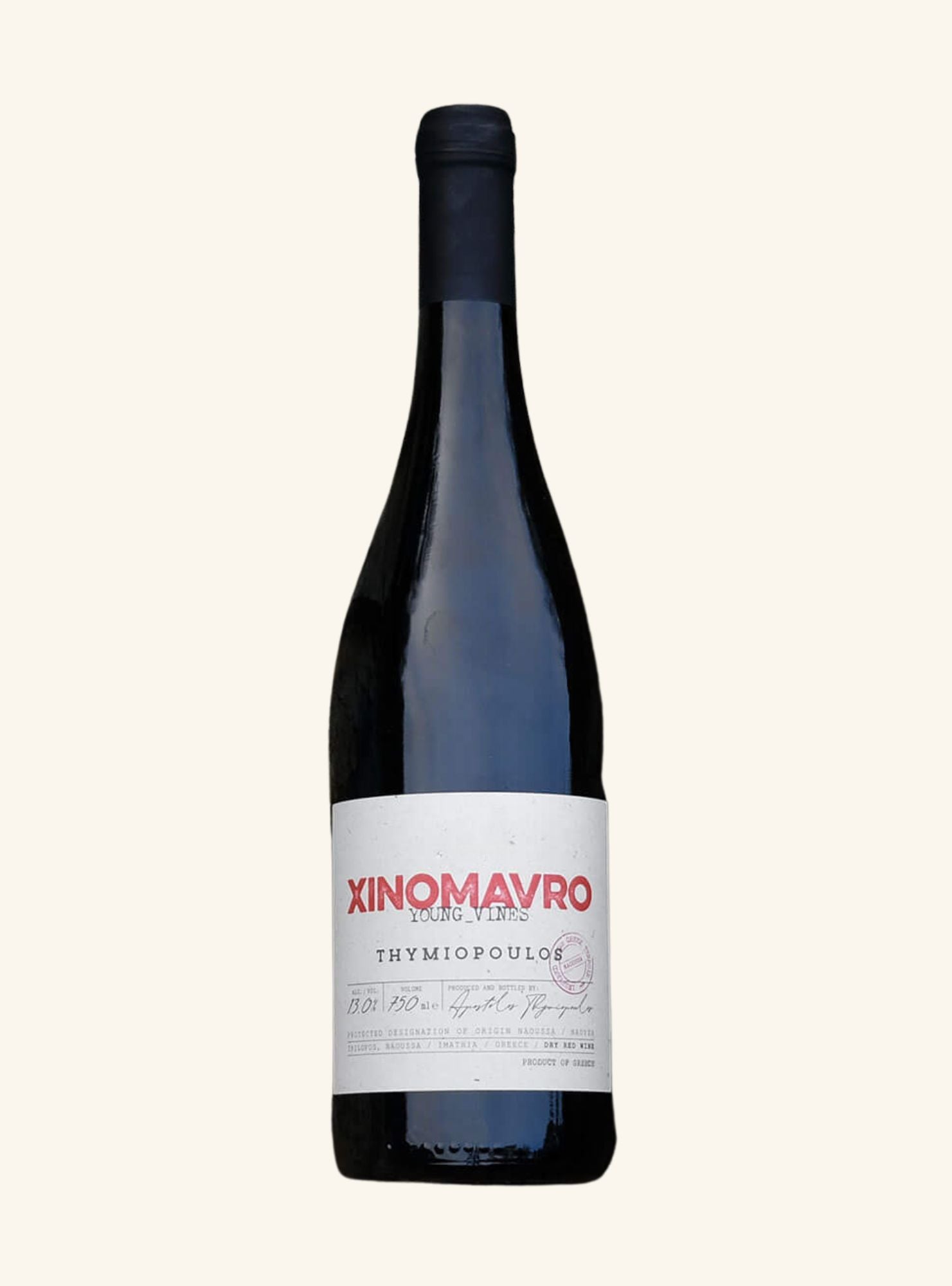 A bottle of Xinomavro Thymiopoulós red wine from Xinomavro Winery, featuring a dark glass bottle with a white label and red lettering, set against a solid off-white background.