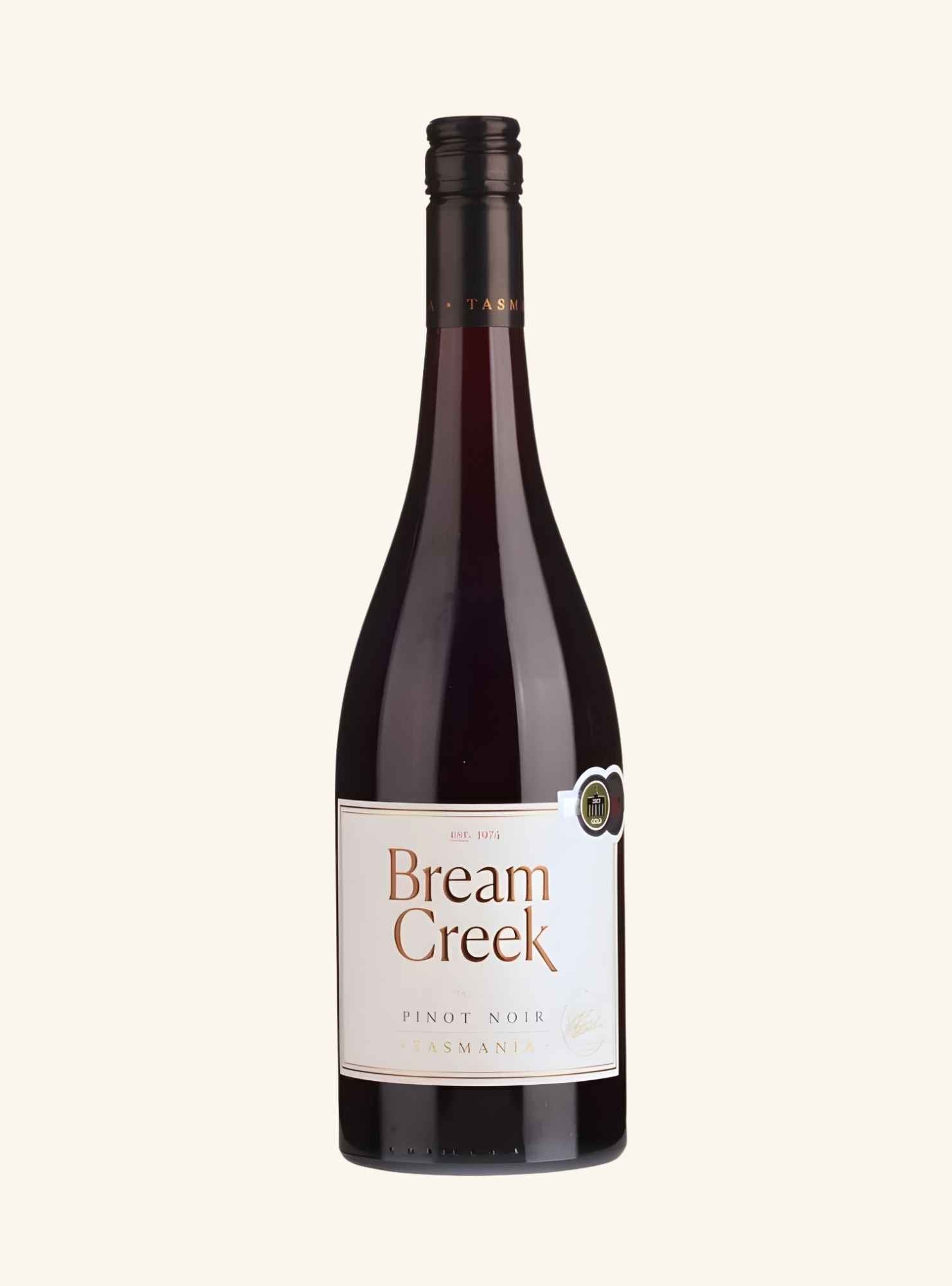 A bottle of Bream Creek Pinot Noir from Tasmania, featuring a dark glass bottle with a cream-colored label and a black screw cap, set against a solid off-white background.
