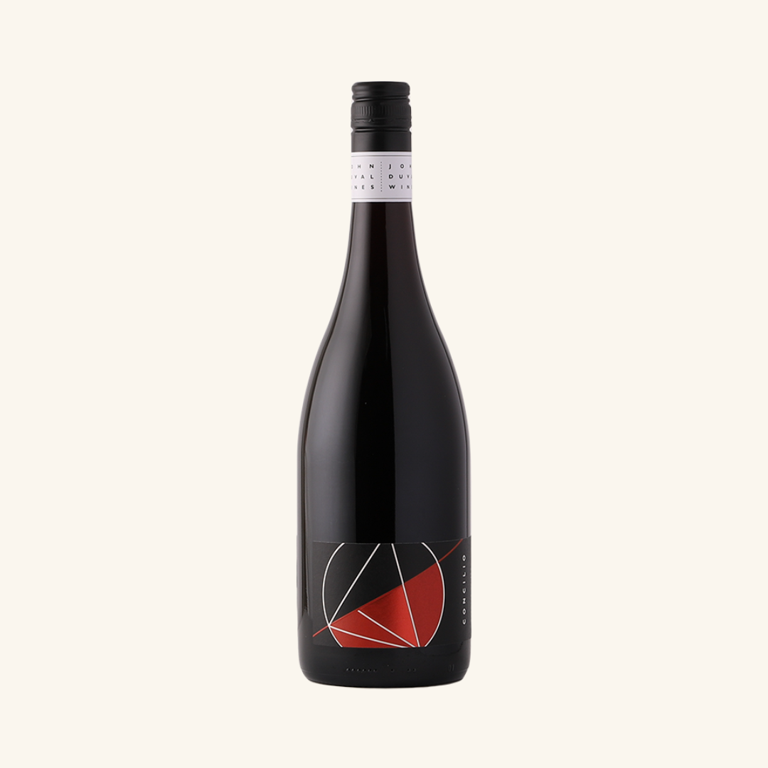 Bottle of John Duval Concilio Grenache Shiraz wine with a predominantly red and white label on a black background.