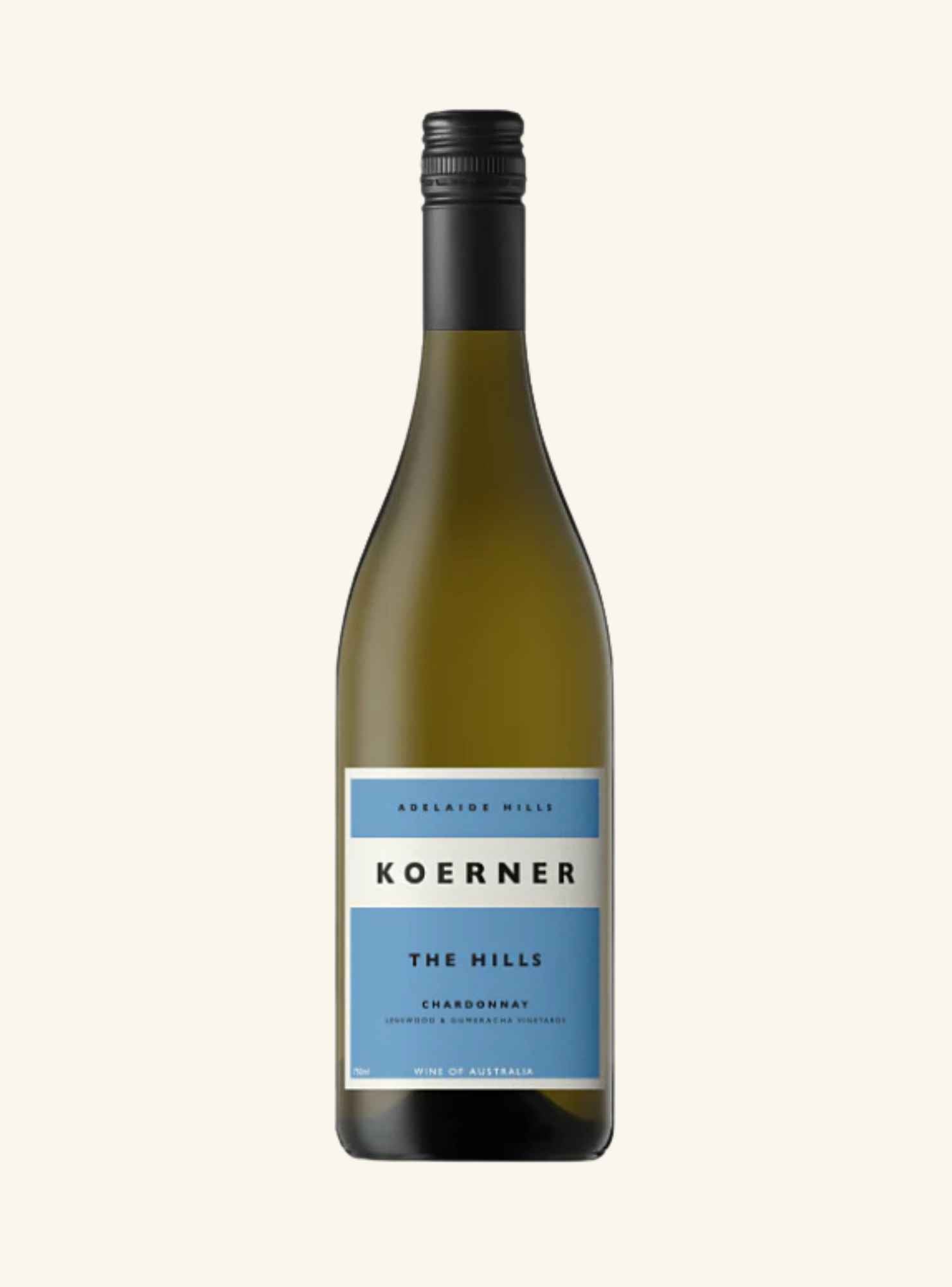 A bottle of Koerner The Hills Chardonnay wine, featuring a dark green glass bottle with a black screw cap and a light blue and white label, centered on a light cream background.