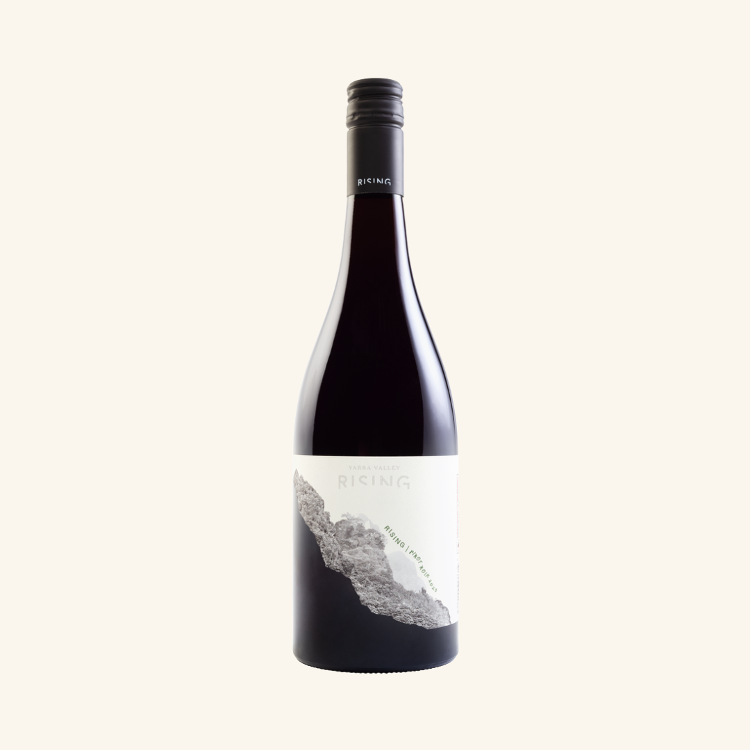 A bottle of Rising Pinot Noir wine with a label depicting a mountain range.