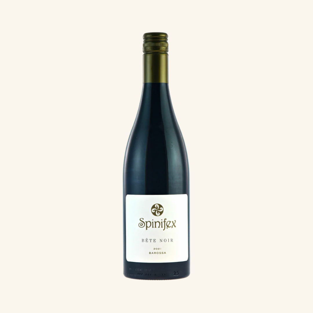 A bottle of Spinifex Bête Noir Shiraz wine with a white label and red text, from the Barossa Valley region.